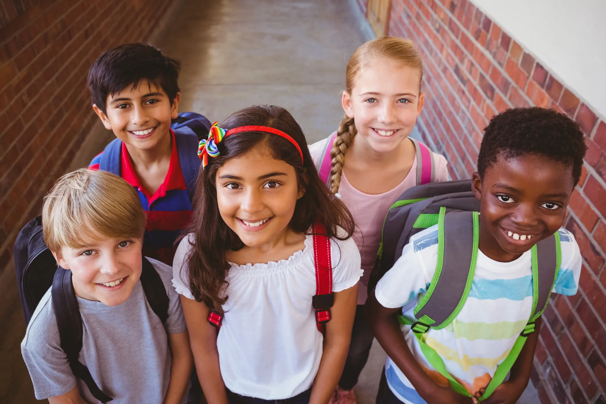 children smiling in corridor at school