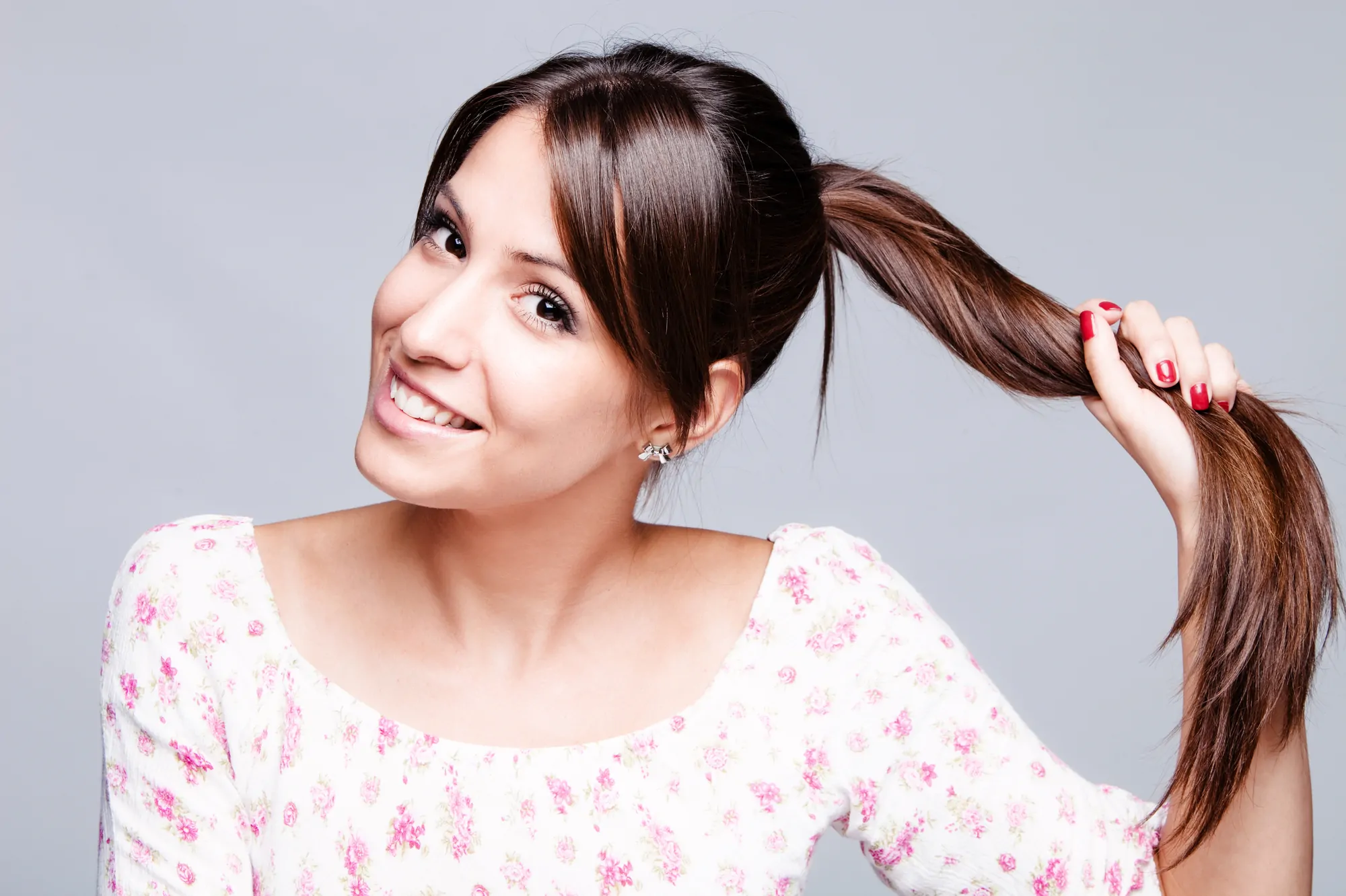 smiling girl hold her long shiny hair