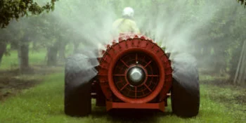 Red sprayer spraying an apple orchard