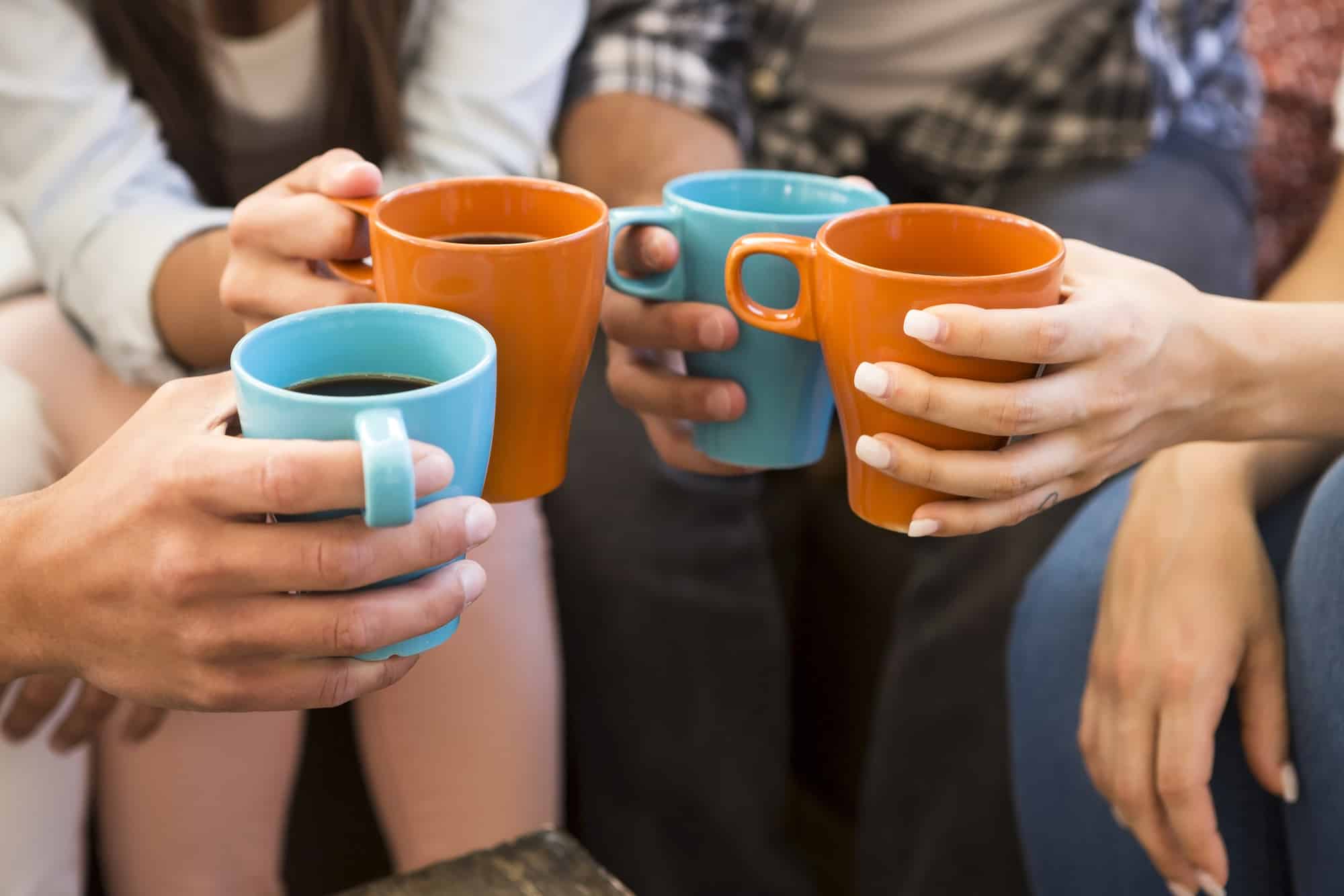 Group of friends making a toast with coffee