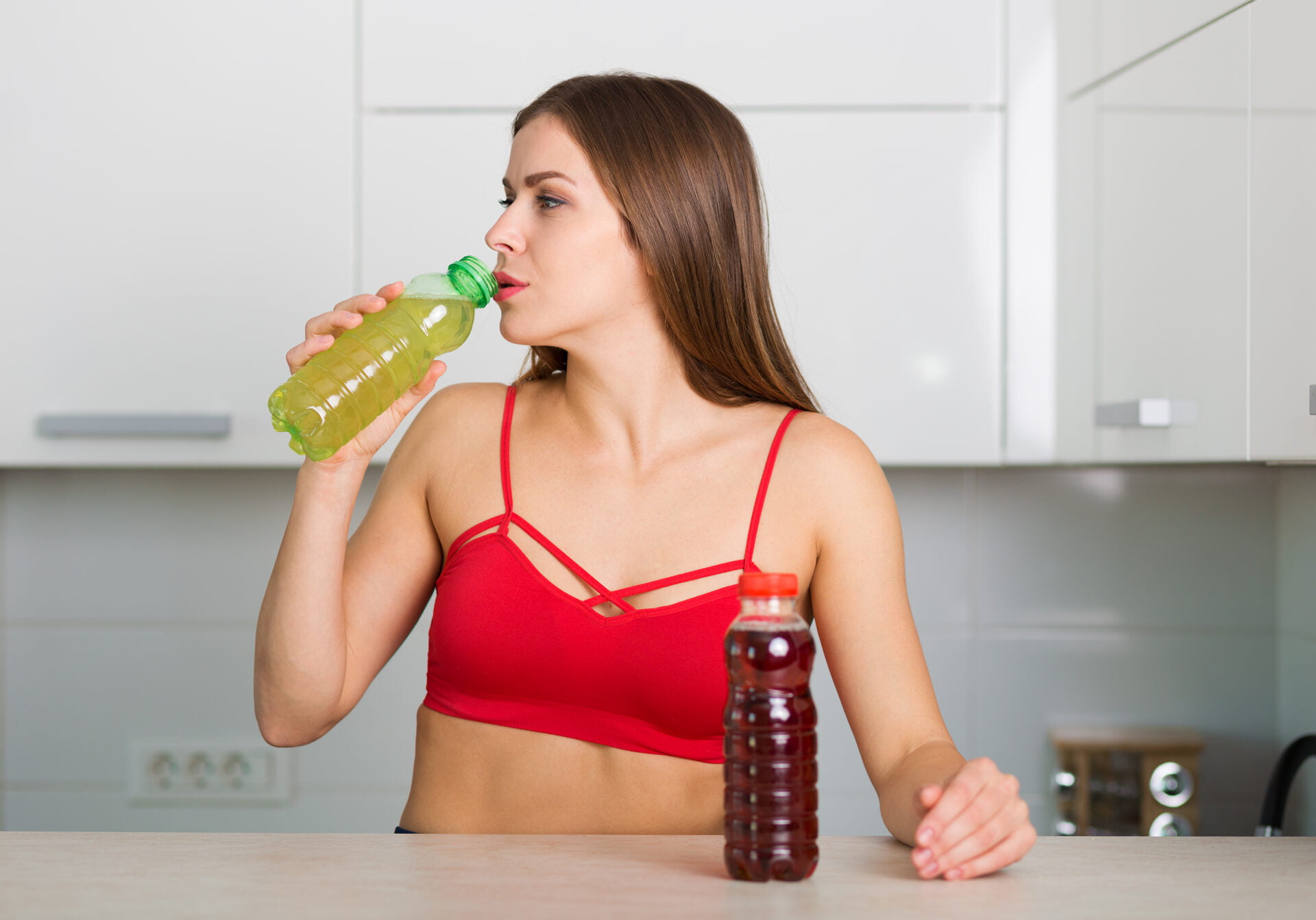 Woman holding two bottles of energy drinks