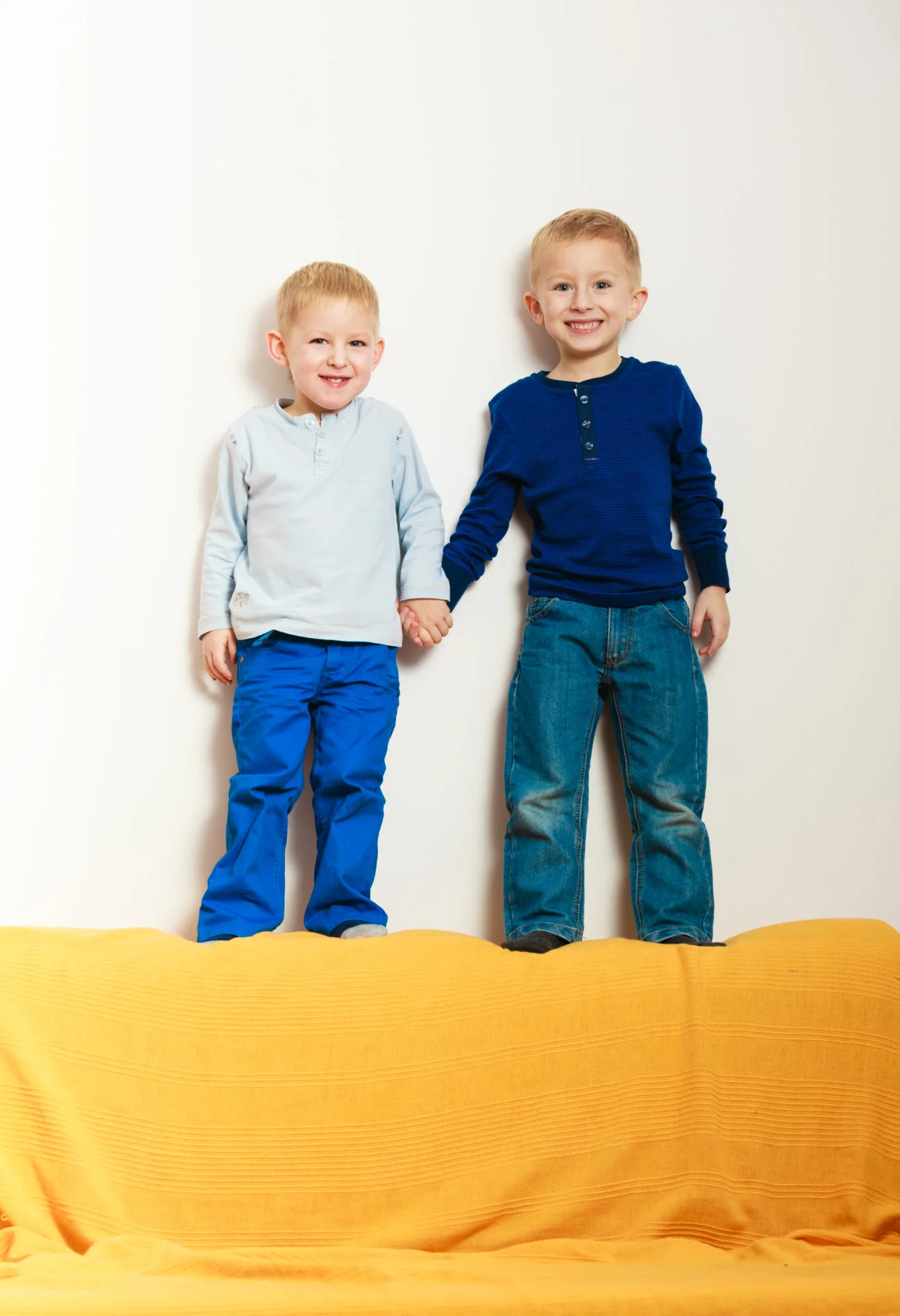 kids on top of foam modular play couch in yellow