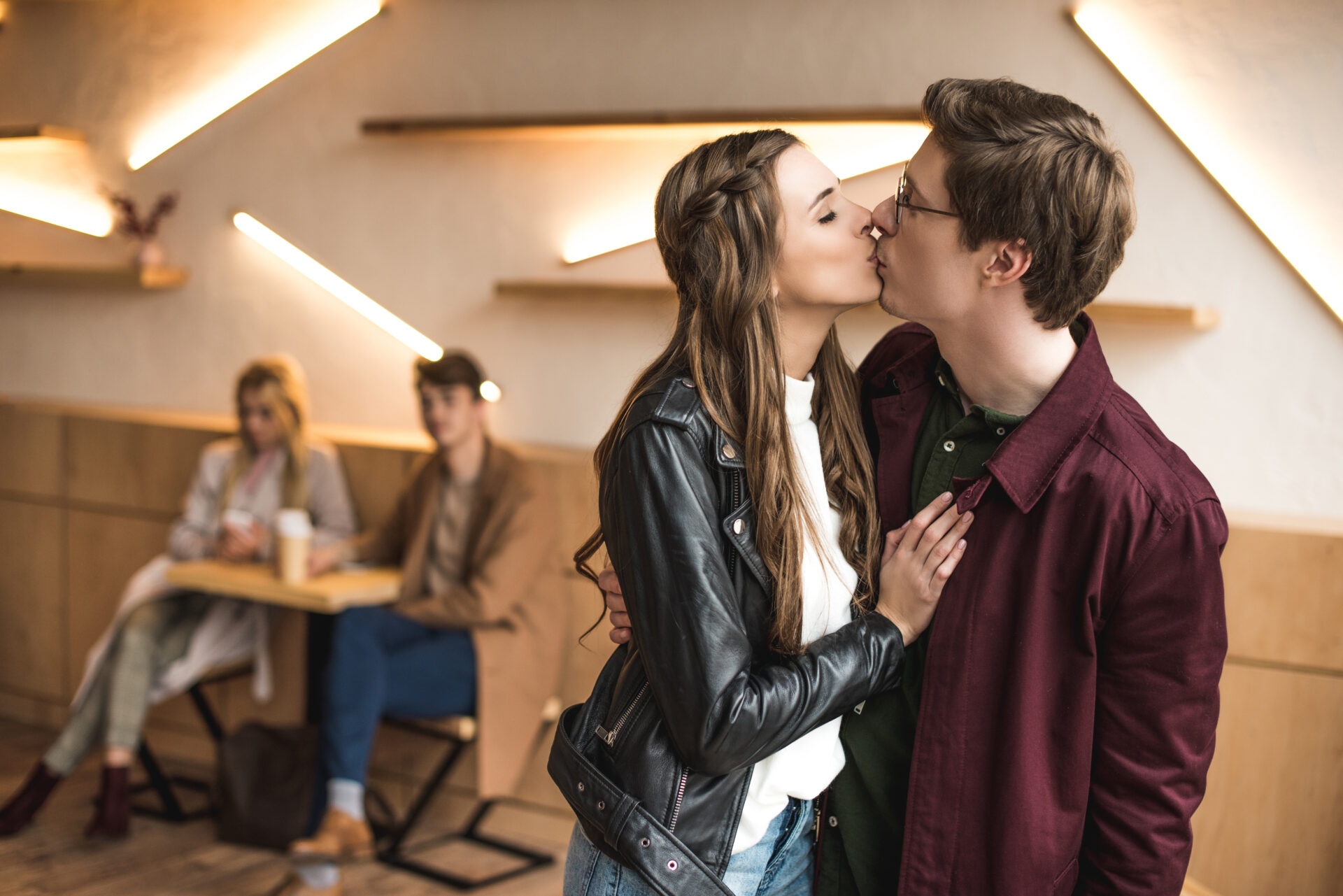 two couples kissing at an event with friends