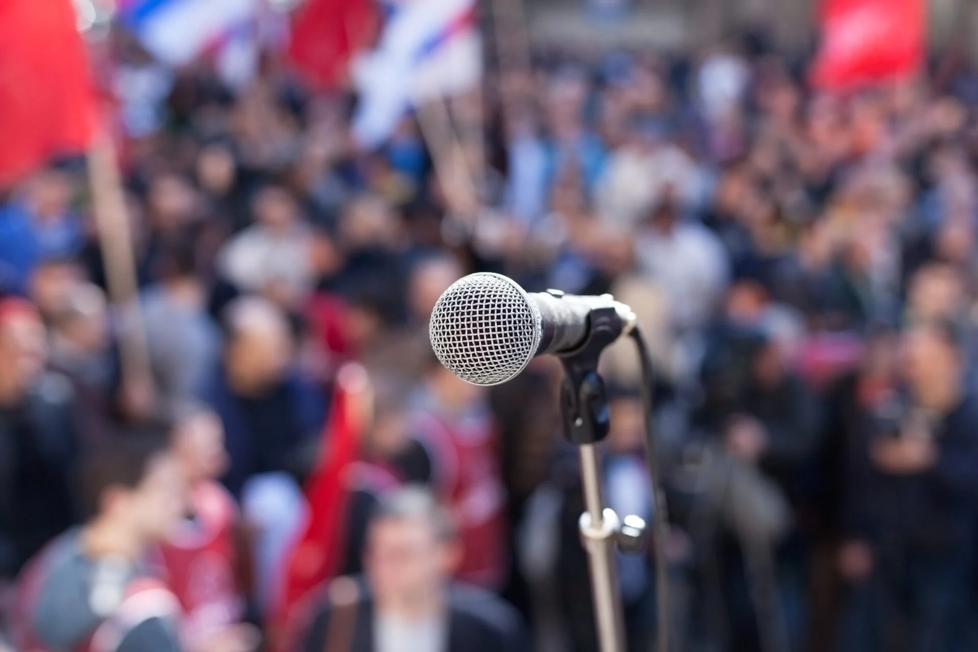 Microphone in focus against blurred audience for a call to action against phthalates in olive oils