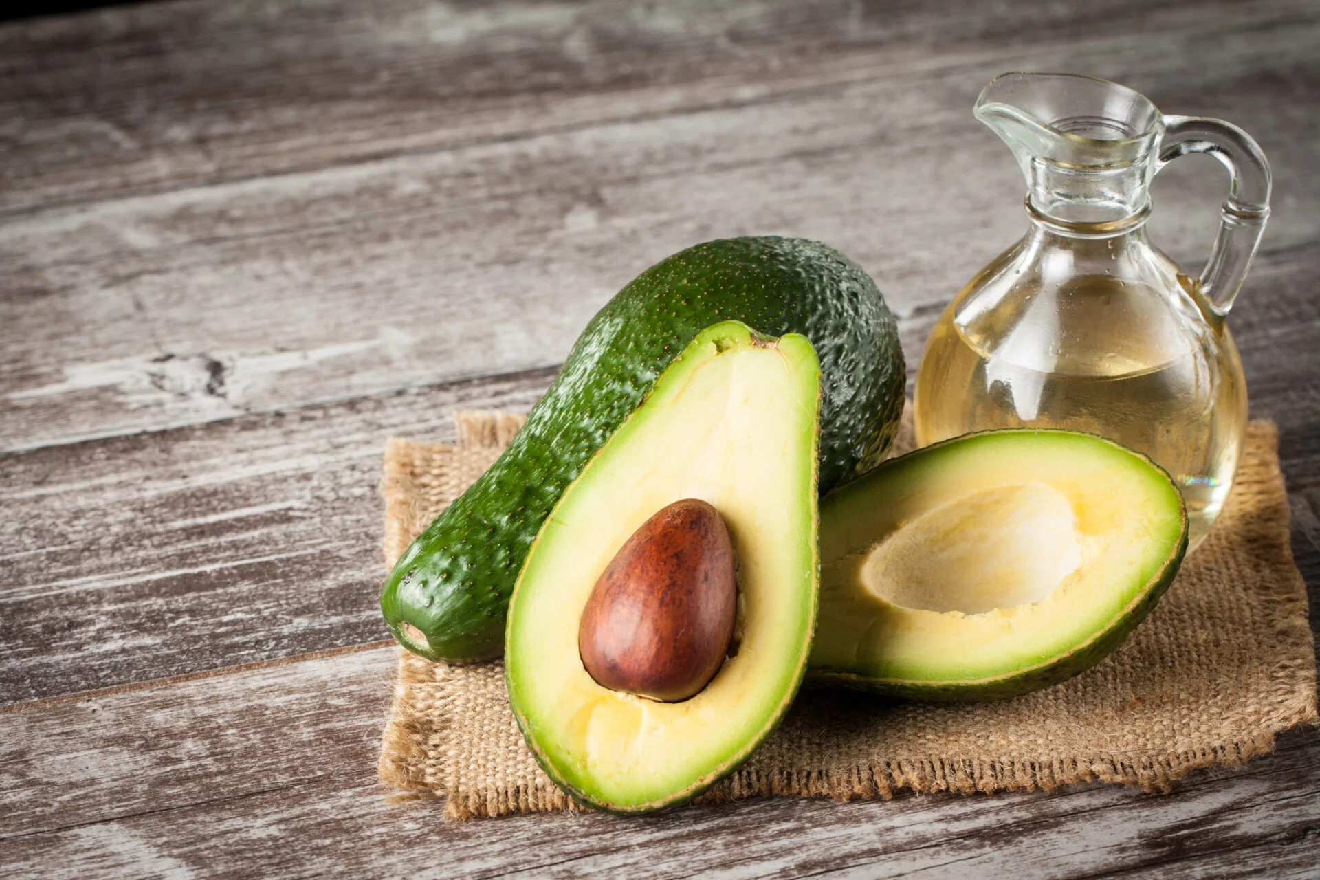 Avocado oils sitting on a wooden table