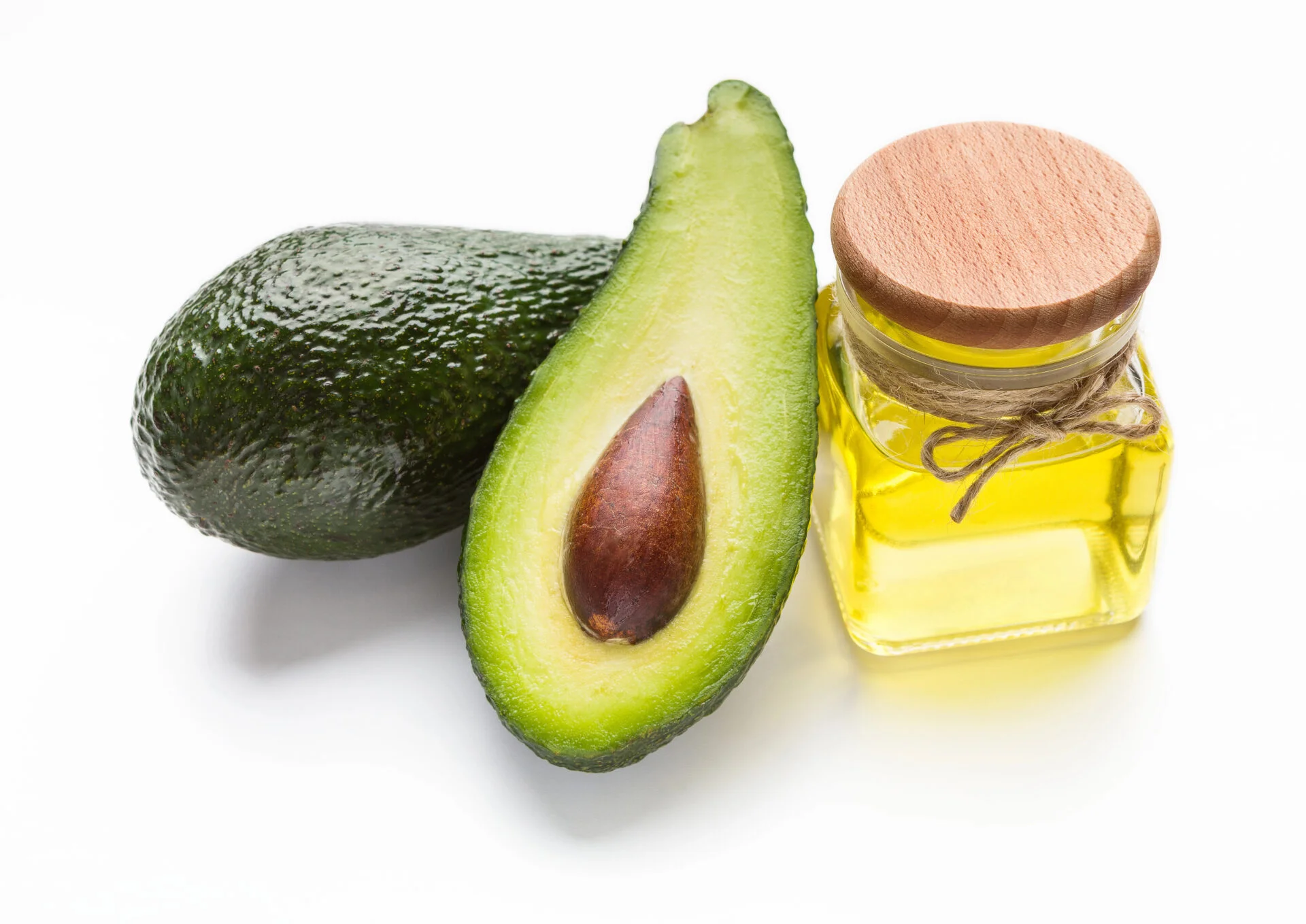 Avocado oil with avocados on a white table