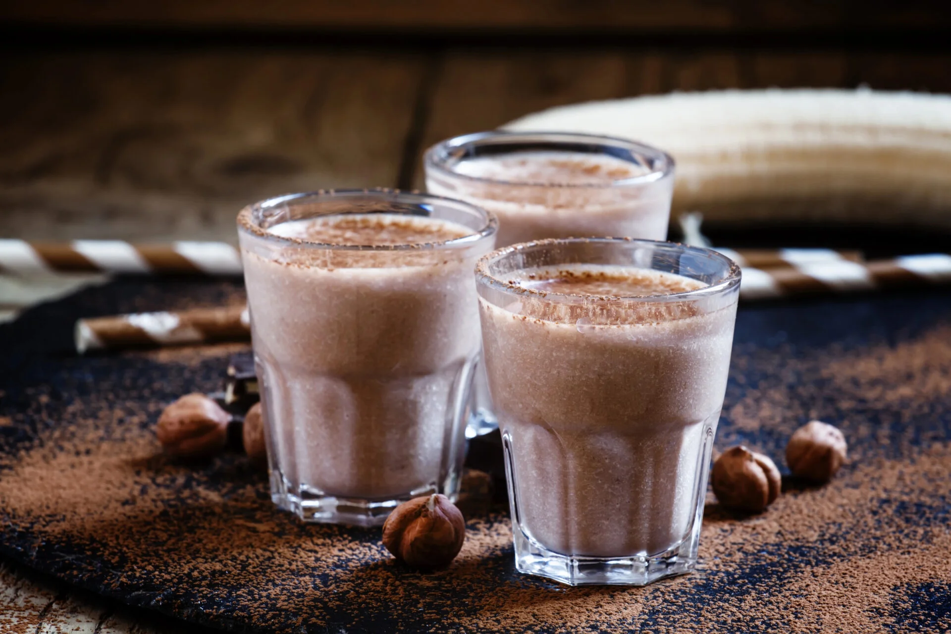 Chocolate protein powder shakes on a wooden table