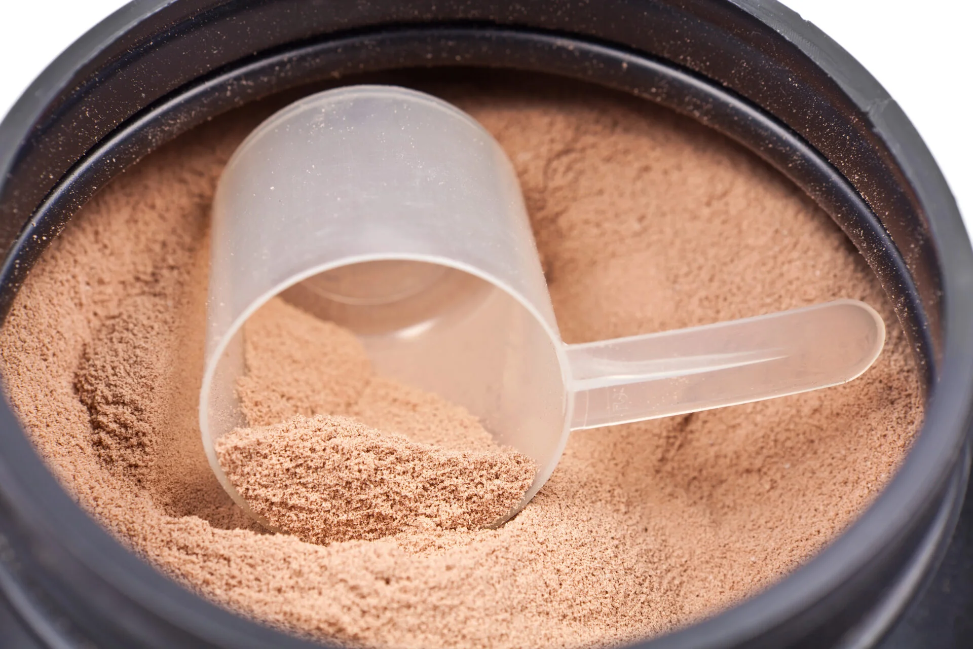 Chocolate protein powder inside black plastic tub