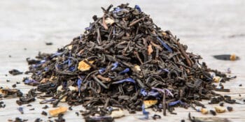 Earl Grey tea leaves on white wood tabletop