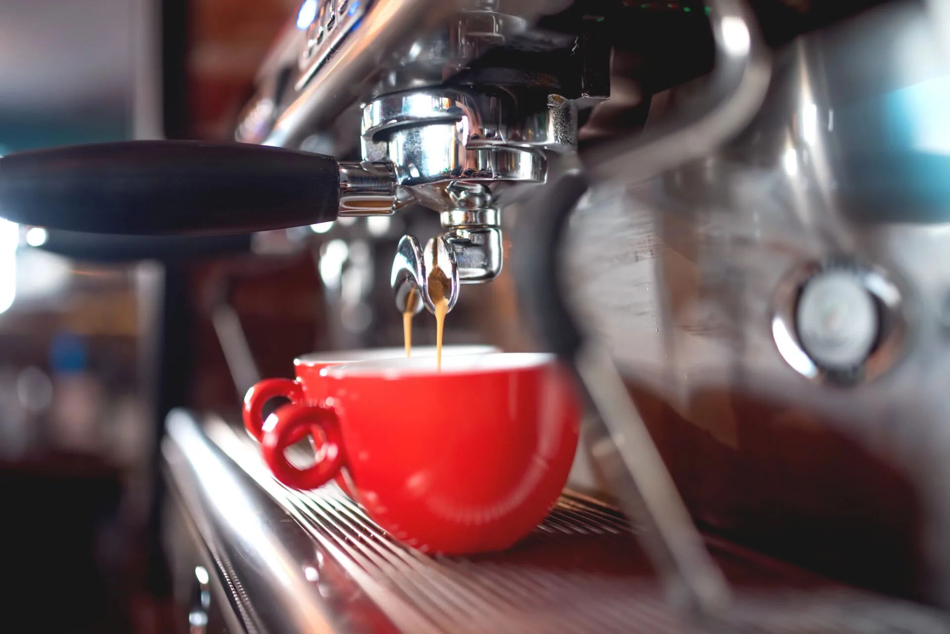 Espresso machine making espresso in a red ceramic cup