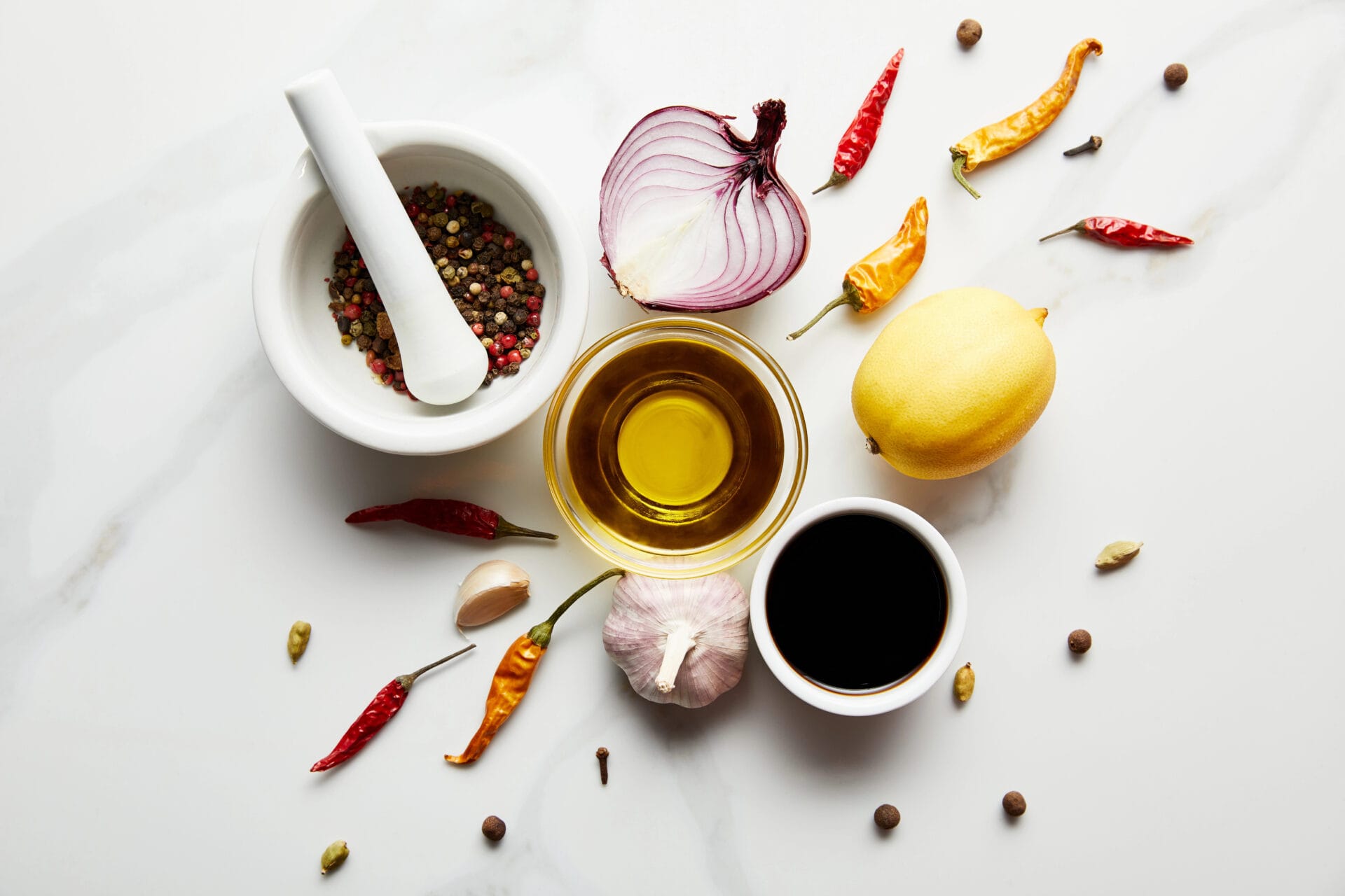 Cooking Oils with onions and spices on a marble table