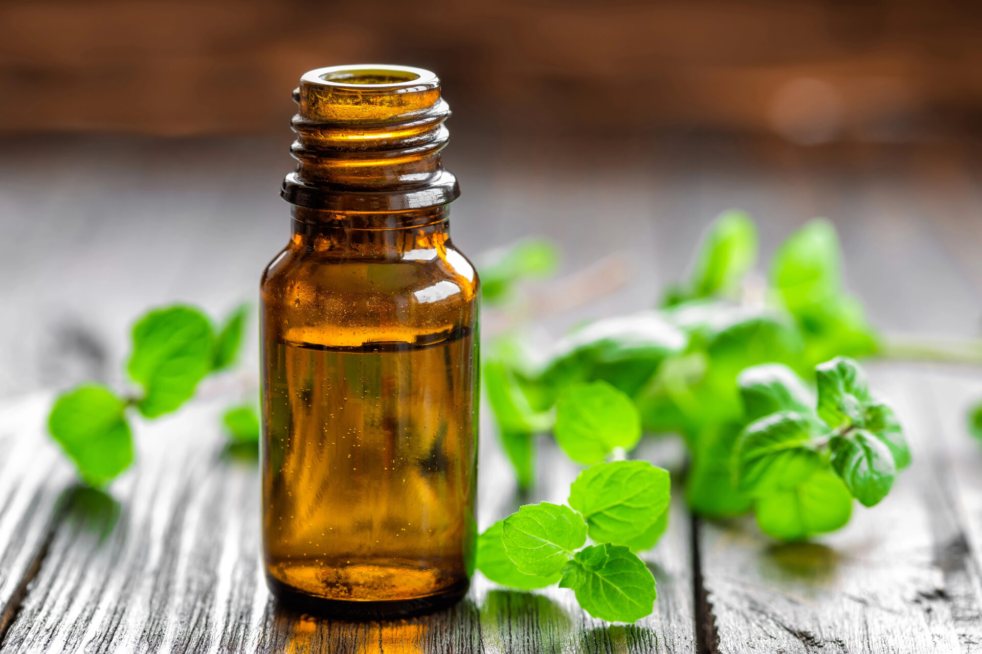 Peppermint essential oil sitting on the wooden table