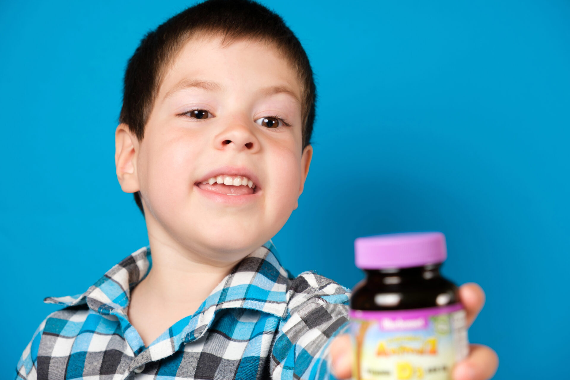 young boy about to eat his multivitamins