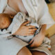 Redhead baby laying on moms lap as she lounges in her robe