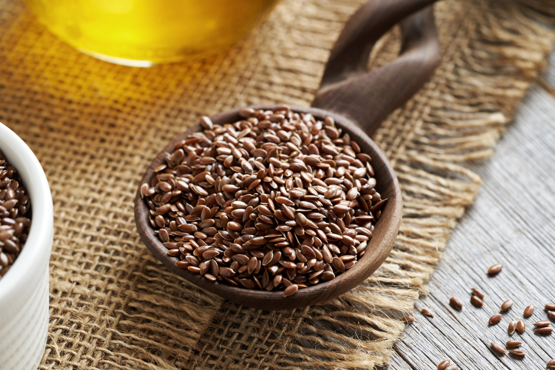 Flaxseed oil next to a bowl of flaxseeds that do not have phthalates
