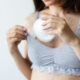 Woman putting in bra the absorbent pad. Selective focus.