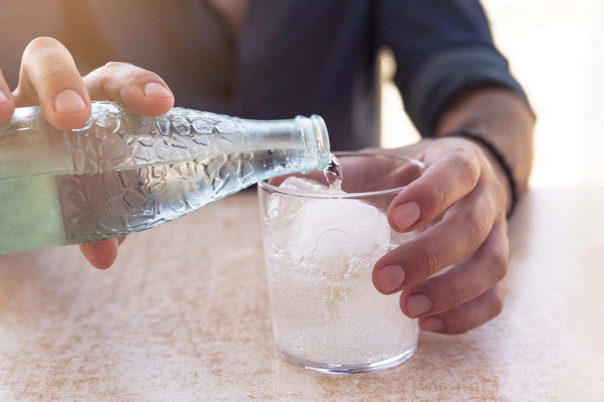 Safest sparkling water tested for PFAS being poured out by a man. 