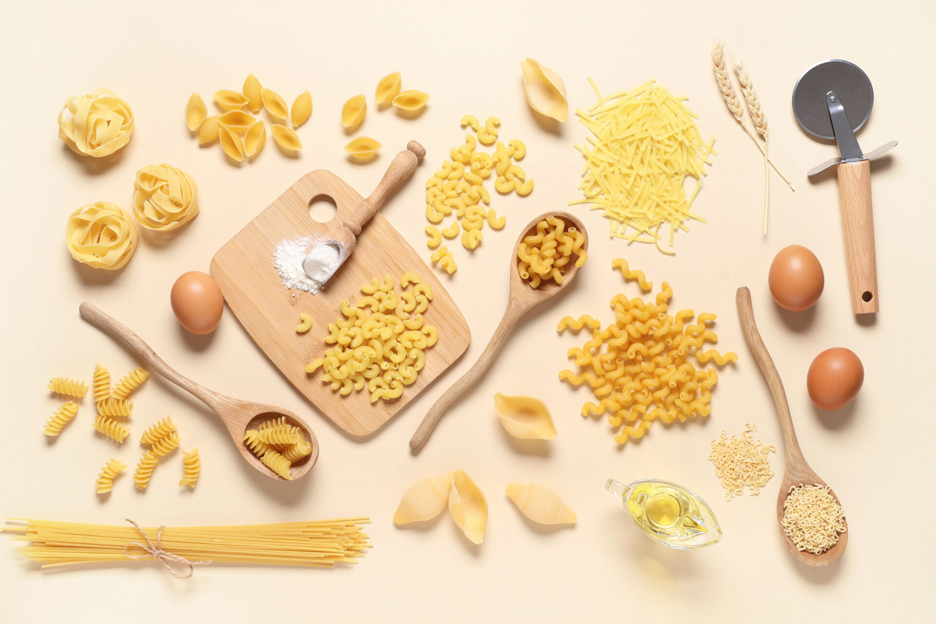 Different types of store bought pasta on a wooden cutting board and table