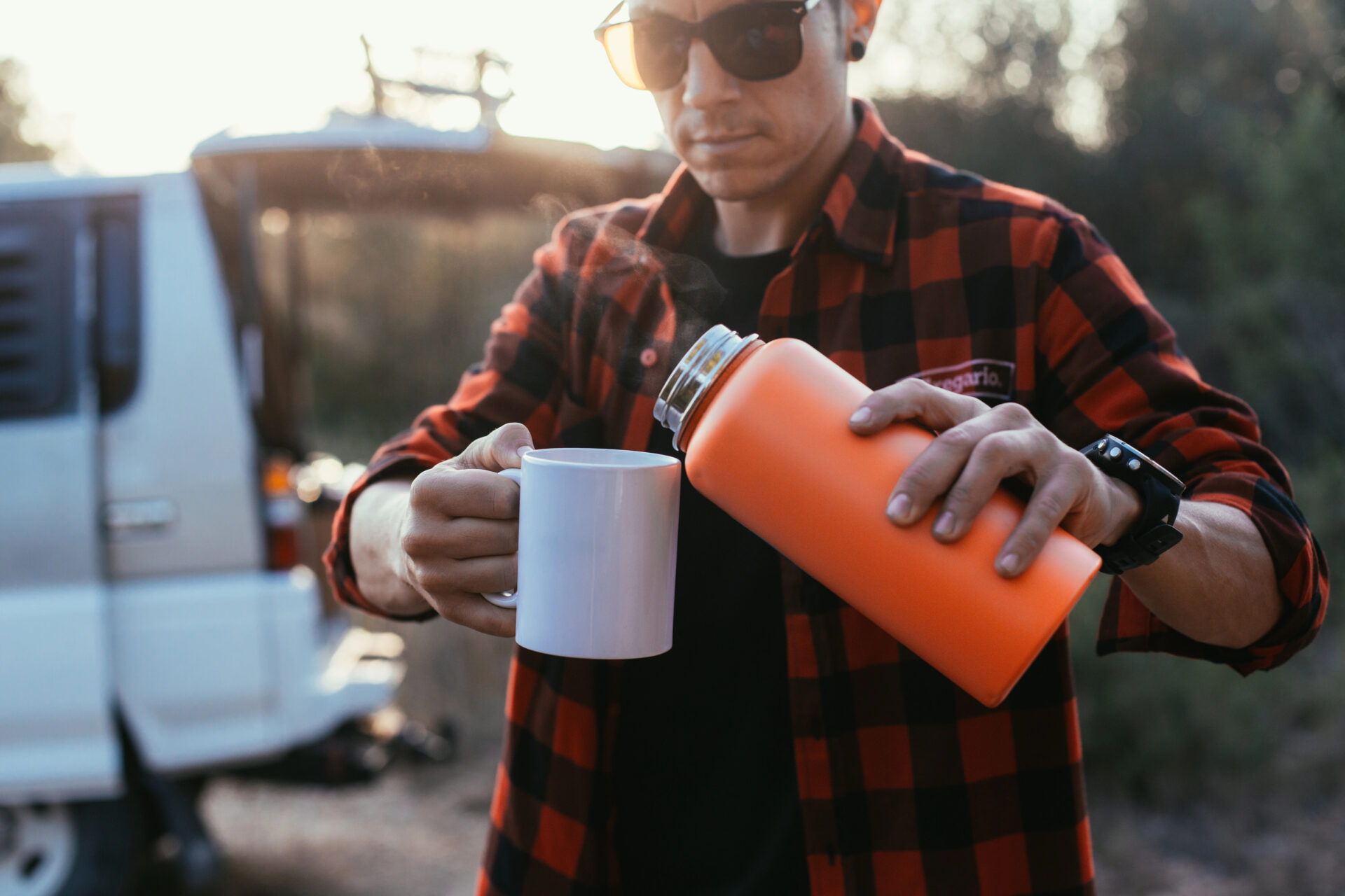 Hot beverage poured into a ceramic mug by man outside
