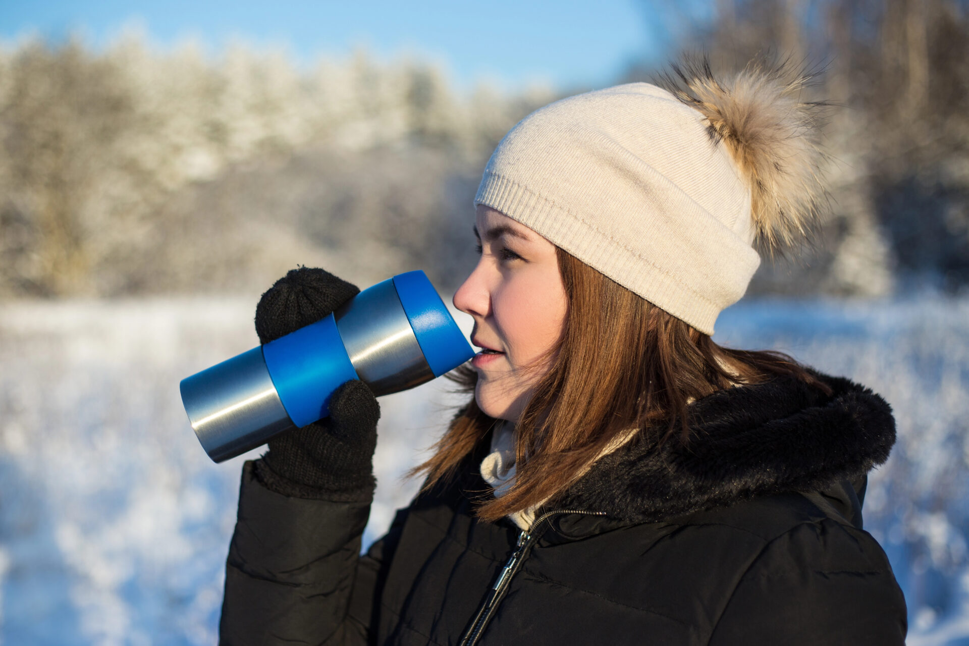 Woman drinking hot tea from a hot beverage mug
