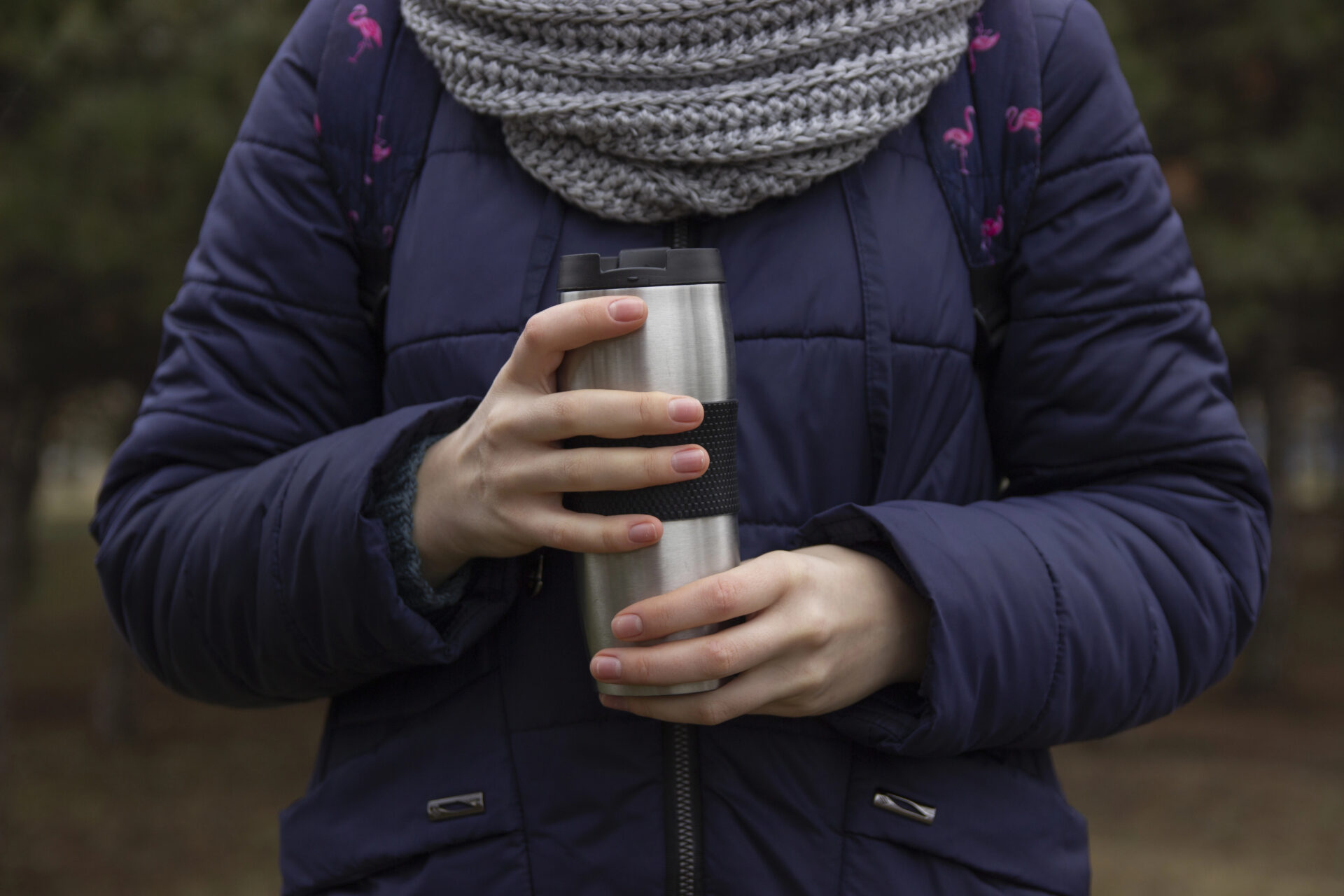 Woman holding hot beverage container in the cold