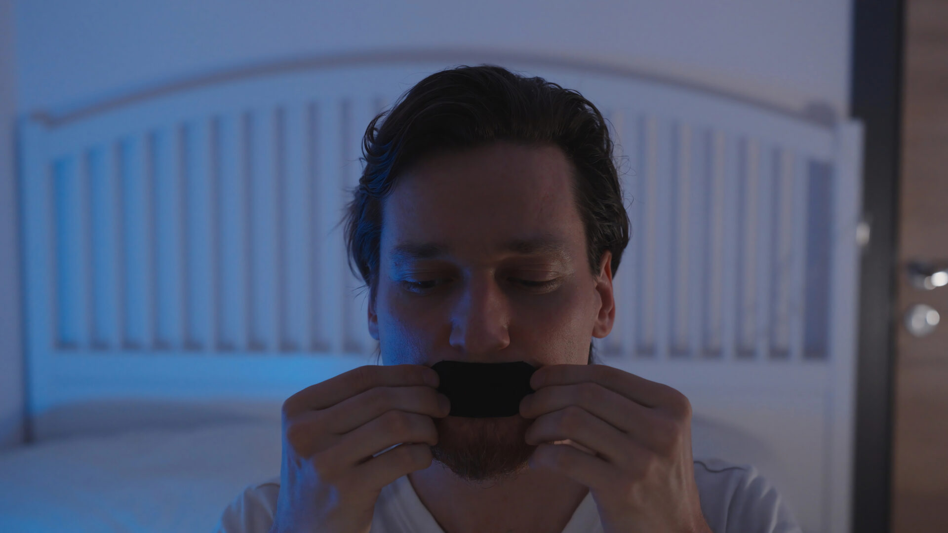 Man puts on mouth tape before he goes to bed at night