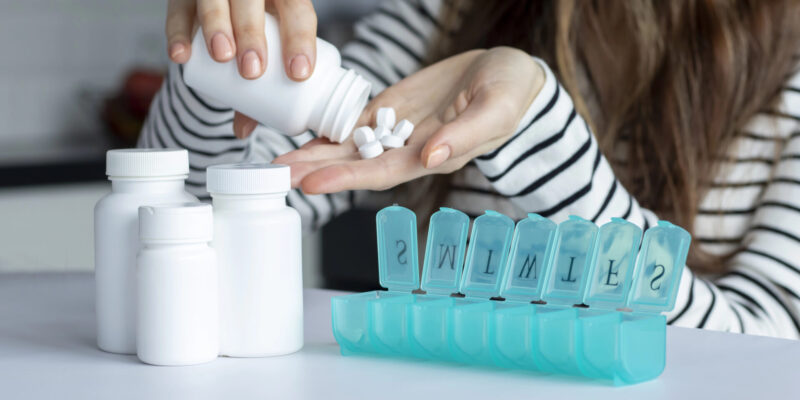Woman pours out multivitamins into her hand