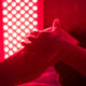 Closeup of sore leg of a person treating with the red light therapy panel
