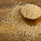 Uncooked brown rice in a wooden bowl. Selective focus