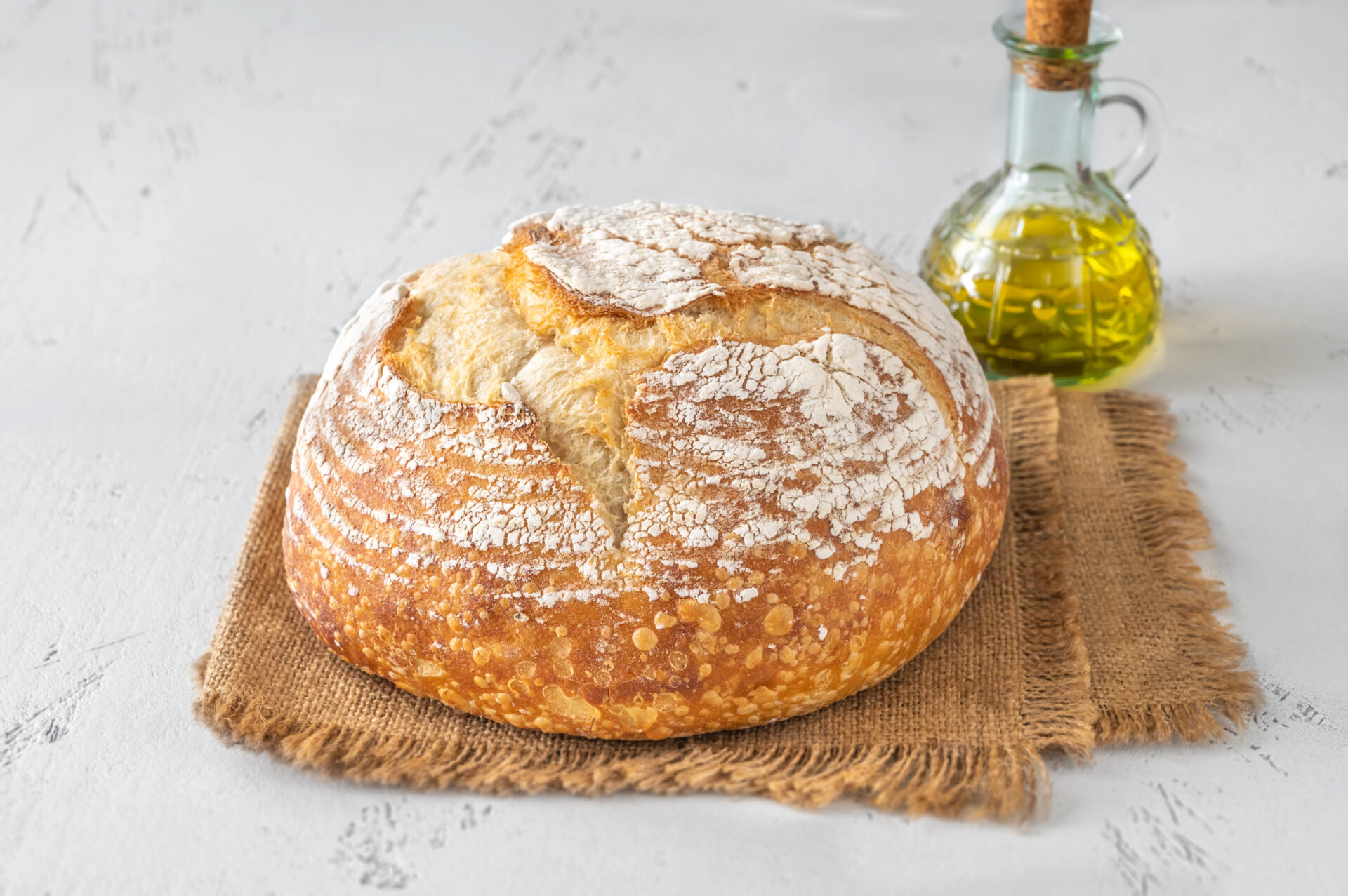 Loaf of fresh sourdough bread on white background