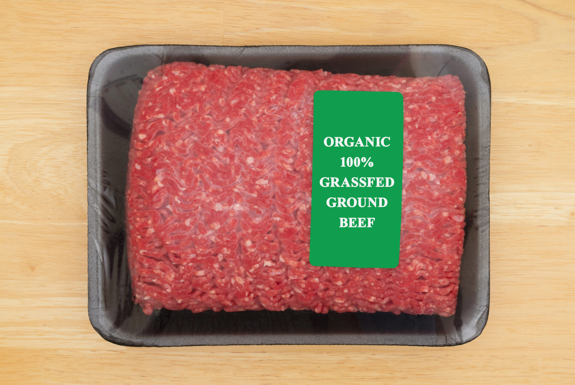 Two pounds of organic grassfed ground beef in package on a cutting board