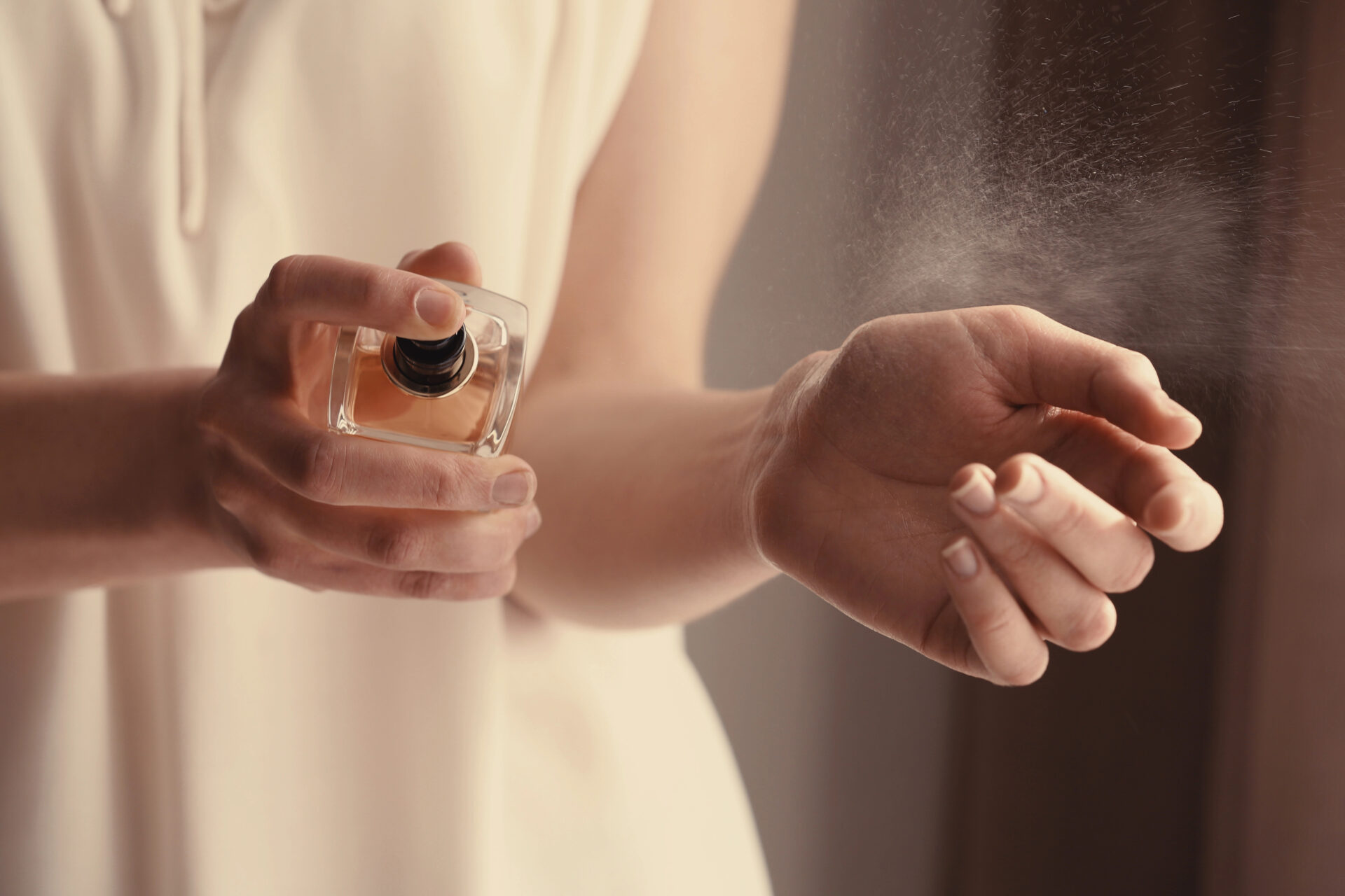 Woman putting perfume on her wrists