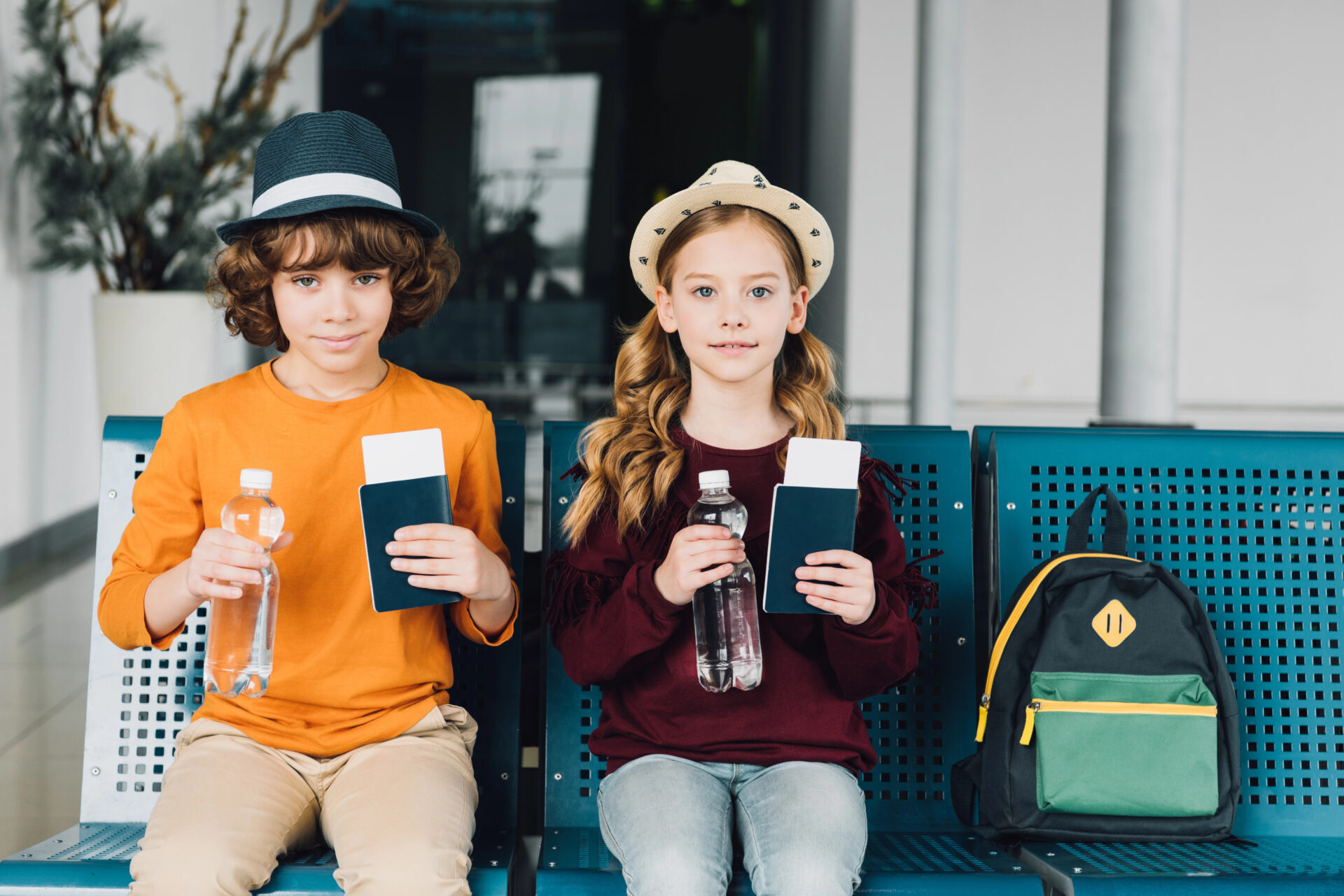 Two kids sitting on a bench with their reusable water bottles
