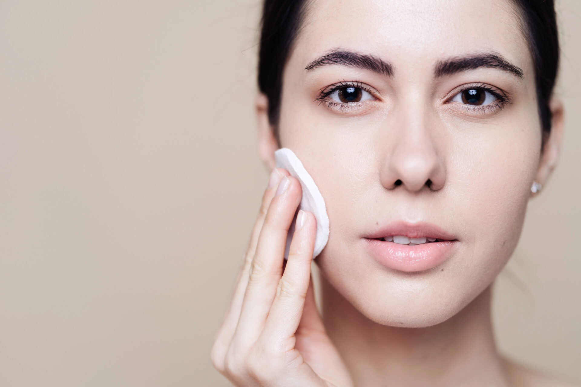 Beautiful women using makeup removal wipe to clean face
