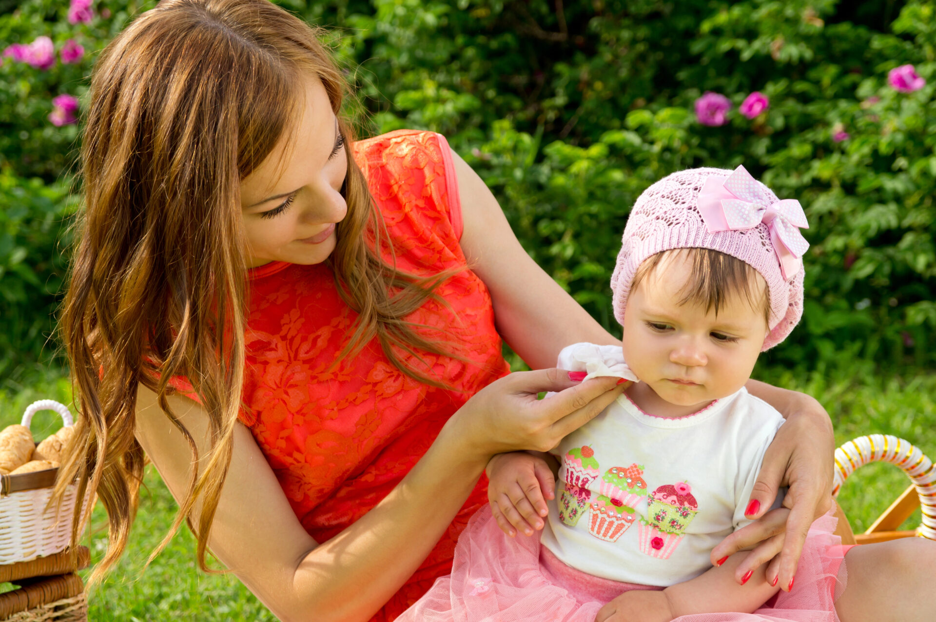 Mom using baby wipe to clean food off toddler
