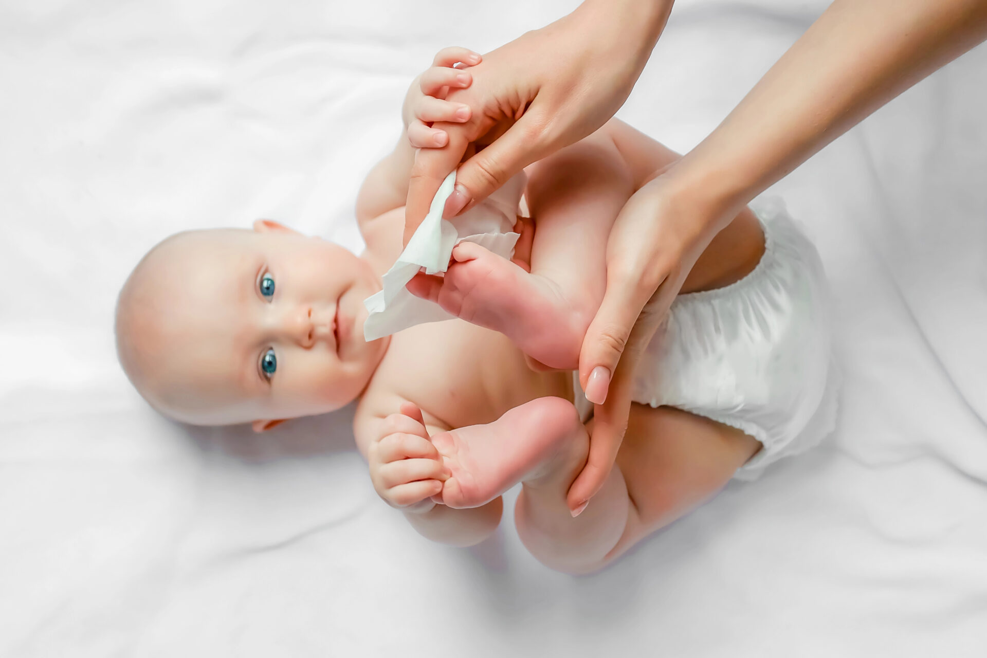 Mother using baby wipe to clean baby