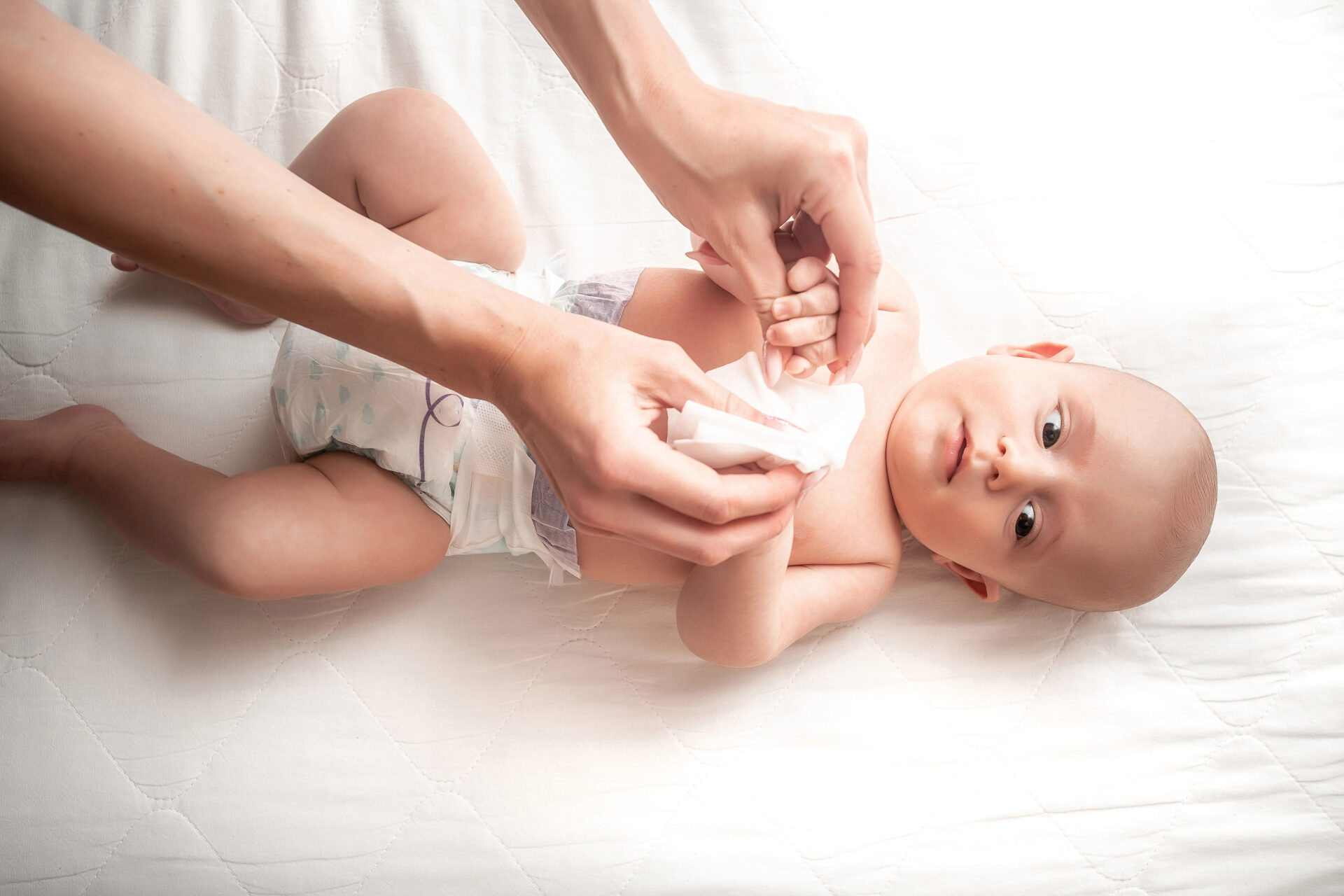 Mother using baby wipe on baby